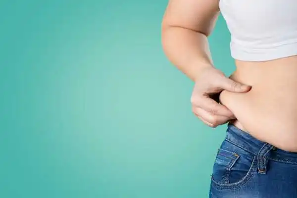 Image of woman pinching her love handles to show weight gain Banbury